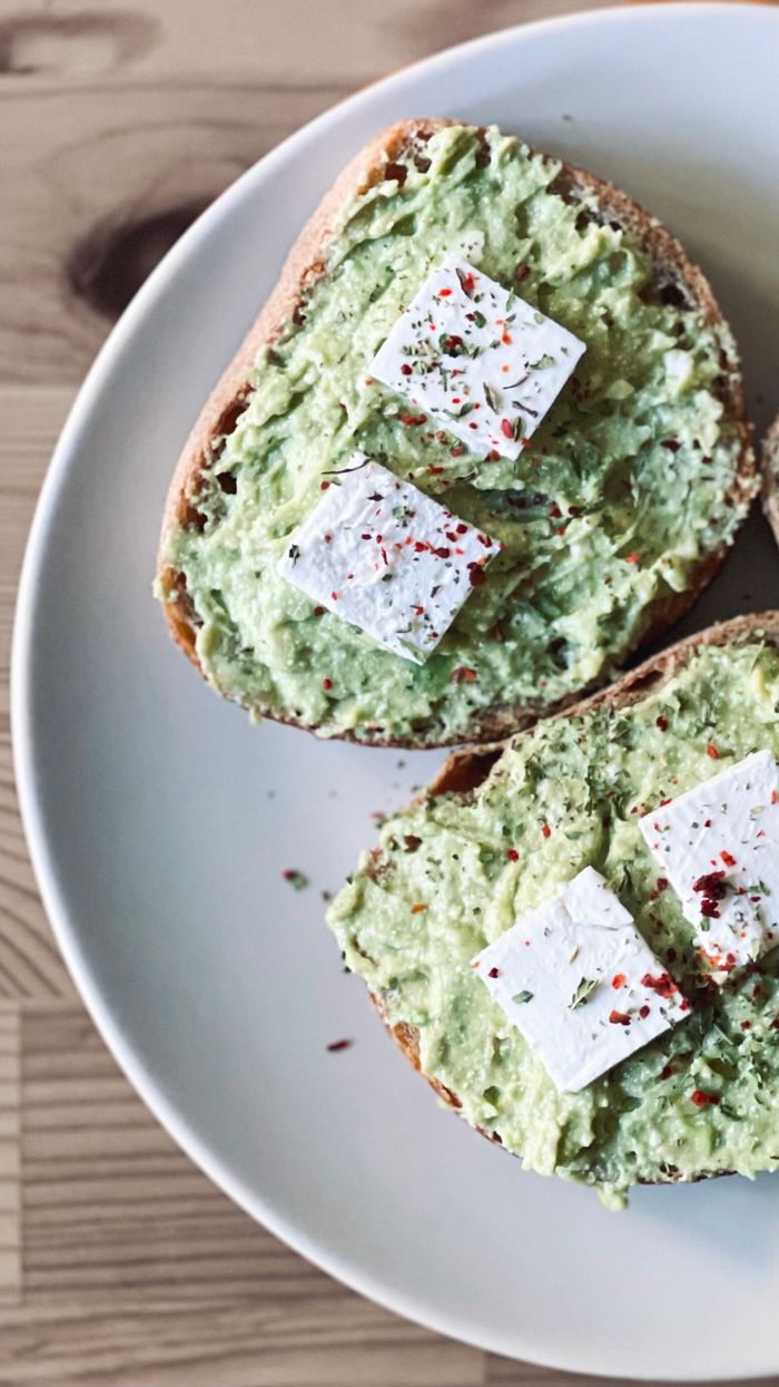 portfolio-img-03 Delicious avocado toast with feta cheese, seasoned with spices, served on a plate.
