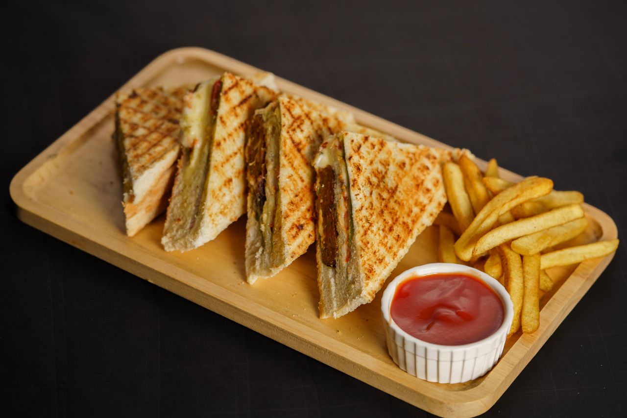 Mastering the First Impression: Your intriguing post title goes here Grilled sandwich with crispy fries and ketchup on a wooden platter.