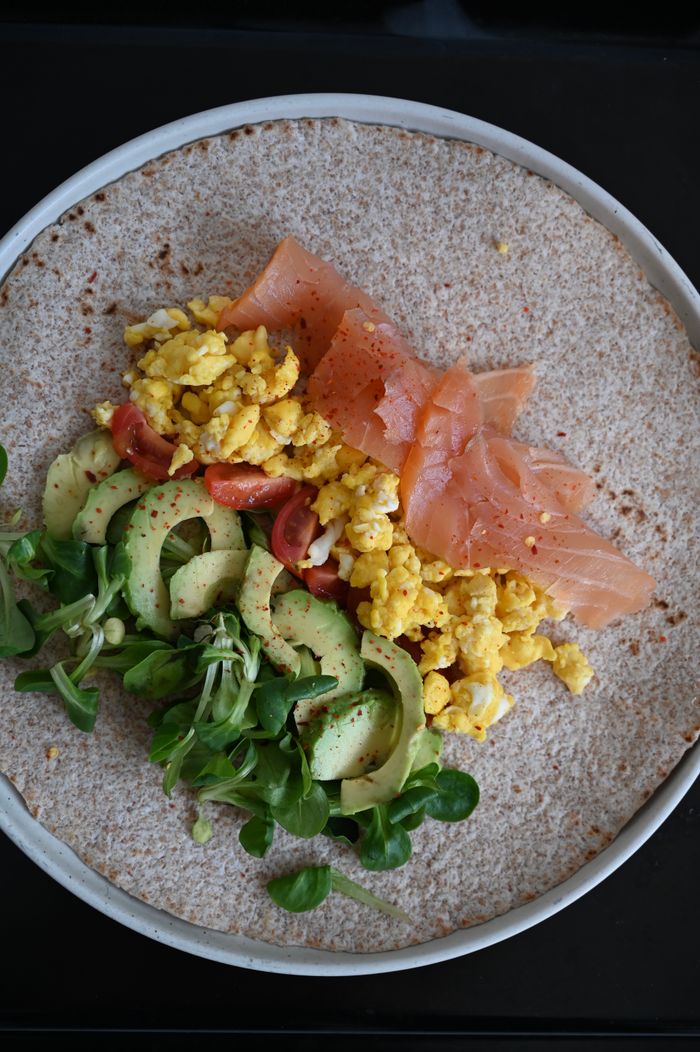 portfolio-img-02 A nutritious wrap featuring smoked salmon, scrambled eggs, and avocado atop a whole wheat tortilla.